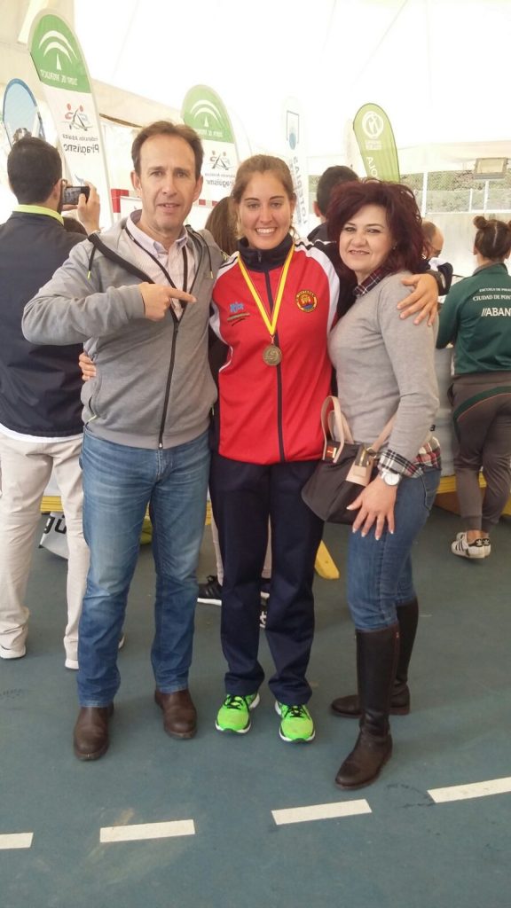 Estefanía Fernández junto a sus padres mostrando la medalla de ORO